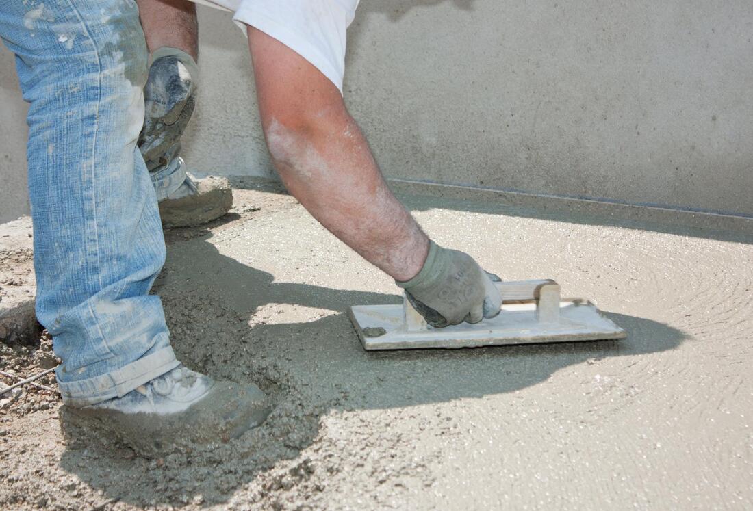 worker resurfacing the concrete flooring