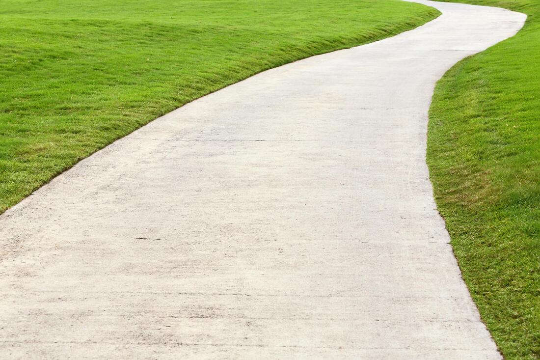 a walkway with lawn on the sides